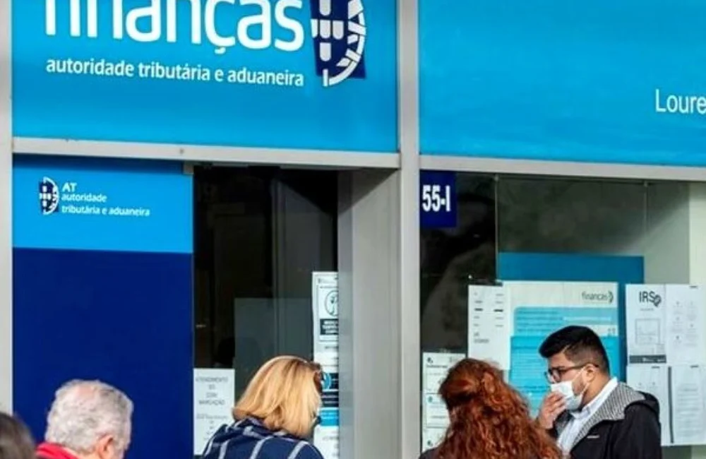 Pessoas a aguardar num balcão das Finanças para alterar a morada fiscal.